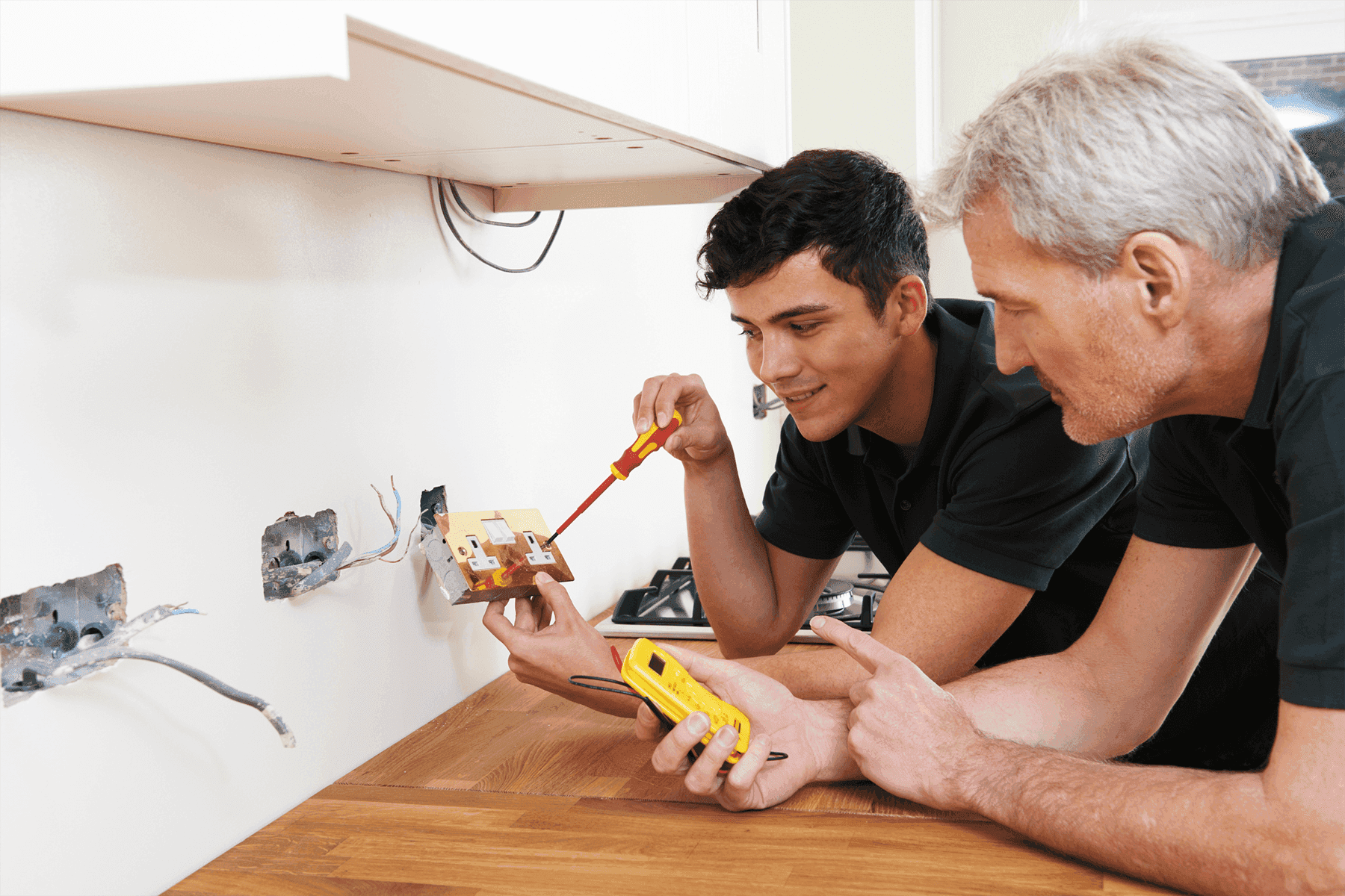 Electricians at work - master and apprentice